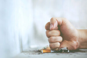 man crushing cigarette with fist